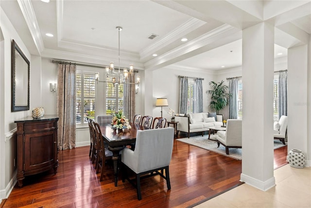 dining area featuring a tray ceiling, visible vents, a wealth of natural light, and hardwood / wood-style flooring