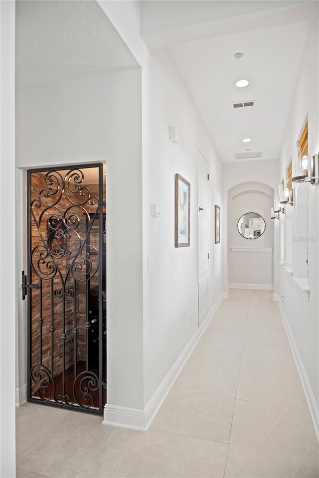 corridor featuring recessed lighting, light tile patterned floors, baseboards, and visible vents