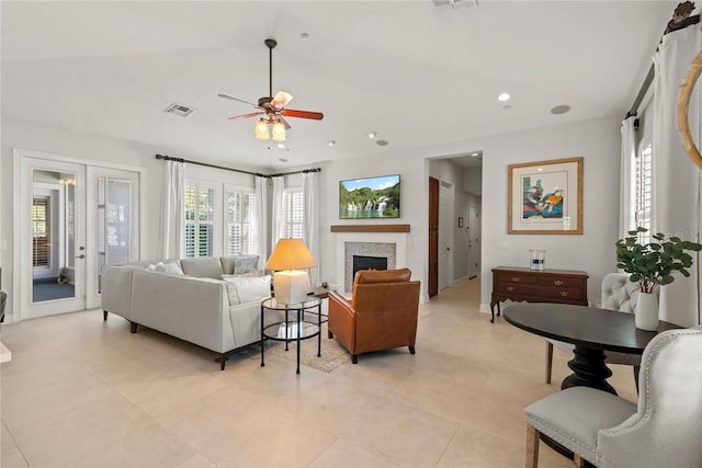 living room featuring visible vents, recessed lighting, a lit fireplace, lofted ceiling, and ceiling fan