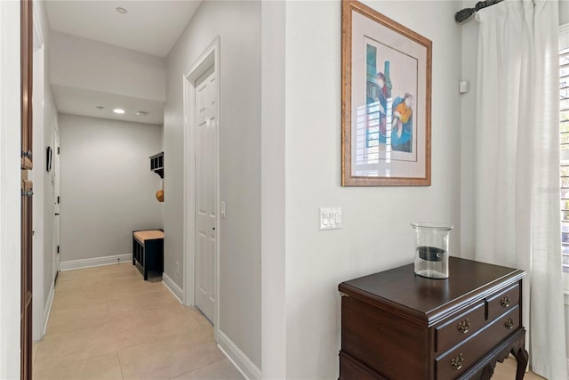 hallway with light tile patterned floors and baseboards