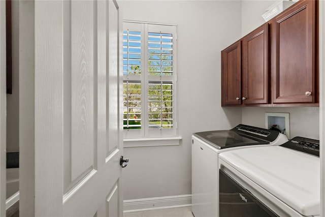 laundry room with cabinet space, independent washer and dryer, and baseboards