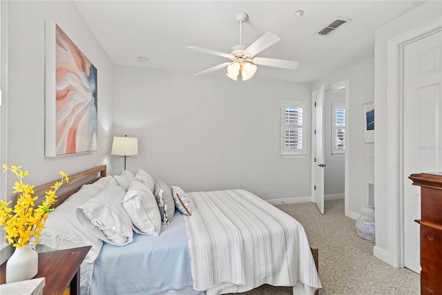 carpeted bedroom featuring visible vents, baseboards, and ceiling fan