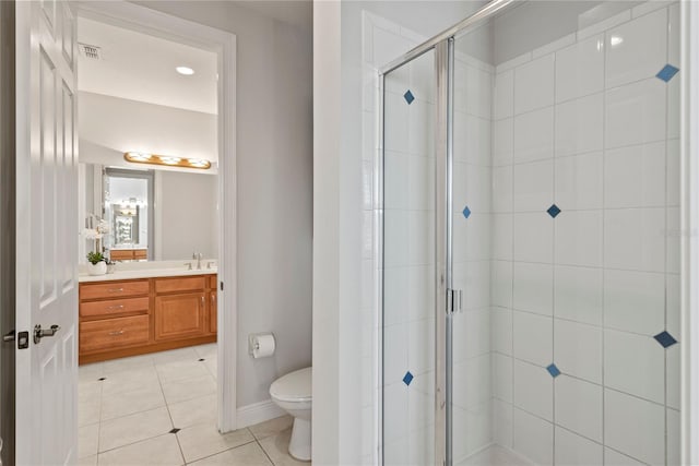 full bath with vanity, baseboards, tile patterned flooring, a shower stall, and toilet