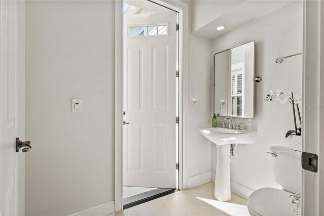 bathroom with toilet and baseboards