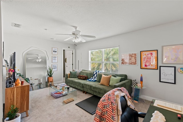 carpeted living room featuring baseboards, visible vents, a textured ceiling, and a ceiling fan