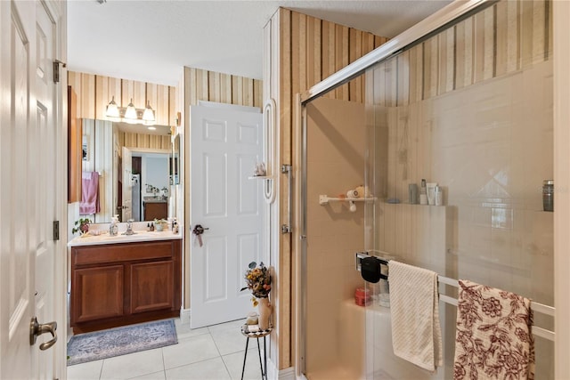 full bathroom featuring wallpapered walls, a shower stall, vanity, and tile patterned flooring