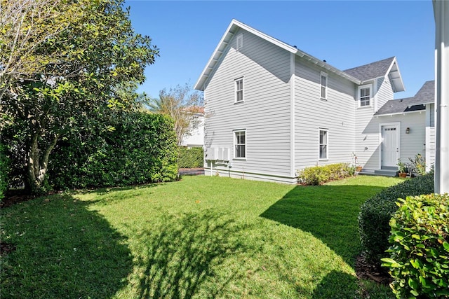 view of property exterior featuring entry steps and a lawn