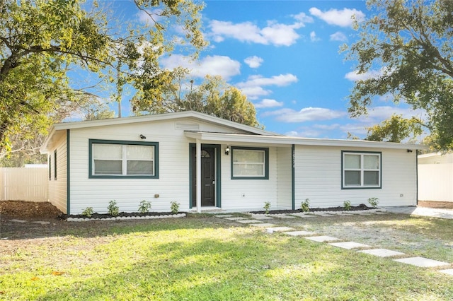 ranch-style house with a front yard and fence