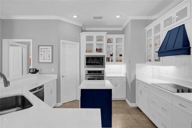 kitchen with black electric stovetop, built in microwave, stainless steel oven, custom exhaust hood, and a sink