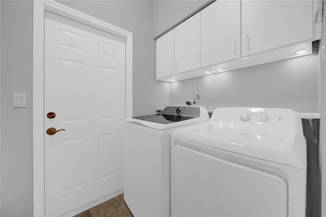 washroom with tile patterned flooring, cabinet space, and washer and dryer