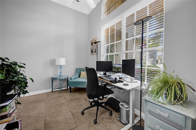 office space with baseboards, a high ceiling, and tile patterned flooring