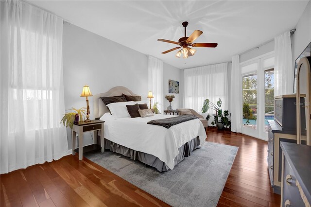 bedroom with dark wood-type flooring, access to outside, and ceiling fan