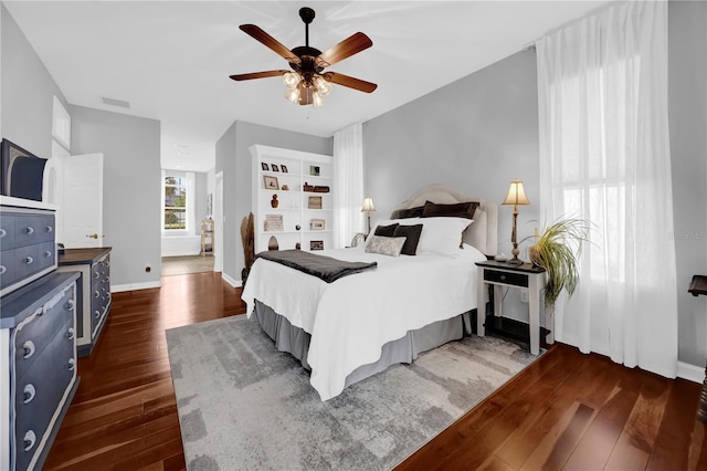 bedroom featuring visible vents, baseboards, ceiling fan, and dark wood-style flooring