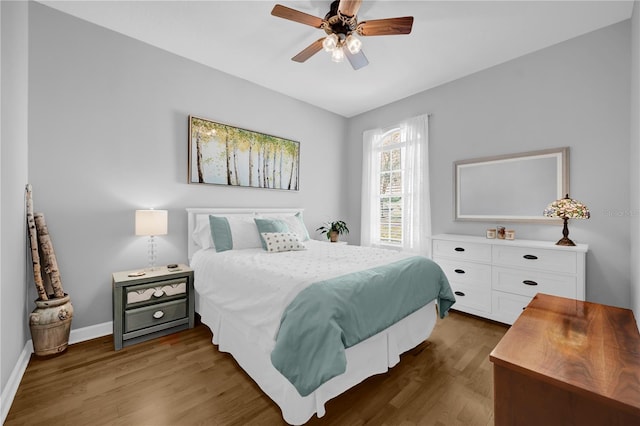 bedroom with a ceiling fan, baseboards, and dark wood-style flooring