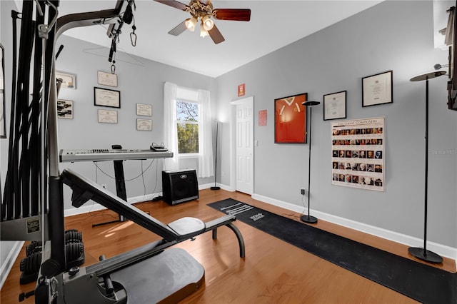 exercise area with baseboards, ceiling fan, and wood finished floors