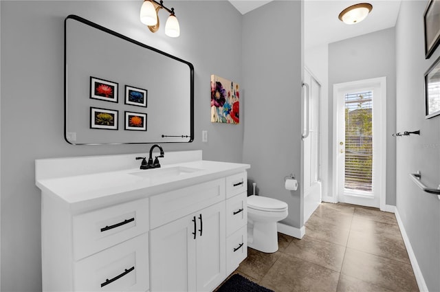 bathroom with vanity, toilet, and baseboards