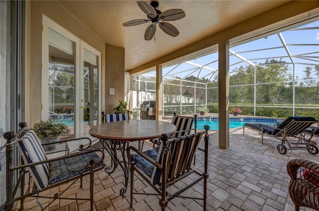 sunroom featuring a swimming pool and a ceiling fan