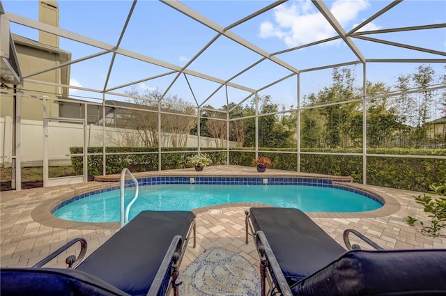 pool with a lanai, a patio, and fence