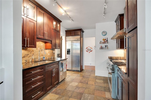 kitchen with a sink, under cabinet range hood, tasteful backsplash, glass insert cabinets, and high end appliances