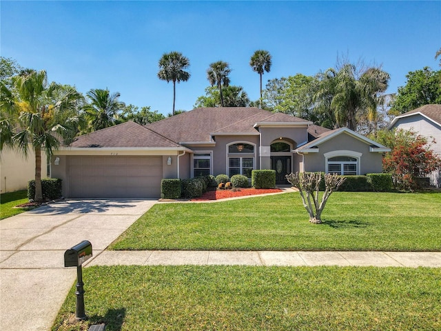 view of front of property featuring stucco siding, driveway, a front yard, and an attached garage