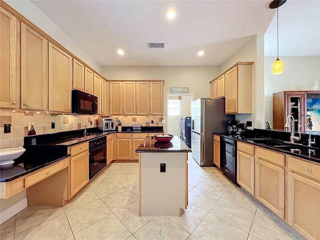 kitchen with visible vents, independent washer and dryer, black appliances, light brown cabinets, and a sink