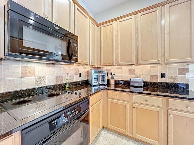 kitchen with black appliances, light brown cabinets, dark stone countertops, backsplash, and light tile patterned floors