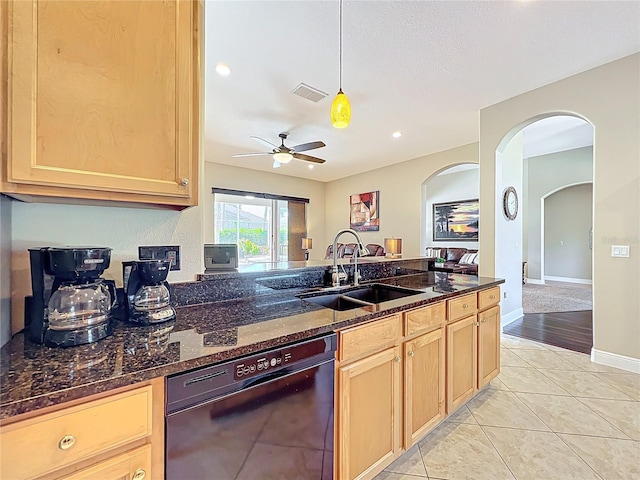 kitchen featuring visible vents, a sink, black dishwasher, dark stone counters, and arched walkways