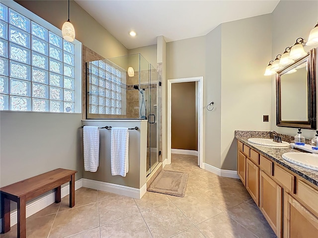 bathroom featuring tile patterned floors, a stall shower, baseboards, and a sink