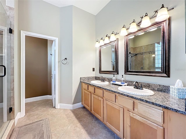 full bathroom with a sink, double vanity, a shower stall, and tile patterned flooring