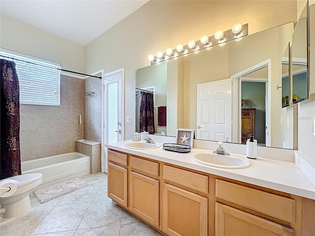 bathroom featuring tile patterned floors, toilet, double vanity, and a sink