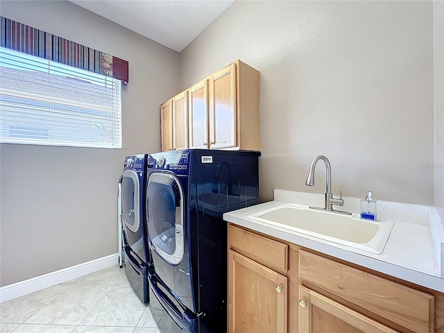 laundry area with baseboards, washing machine and dryer, light tile patterned floors, cabinet space, and a sink