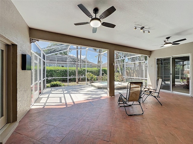 unfurnished sunroom featuring ceiling fan