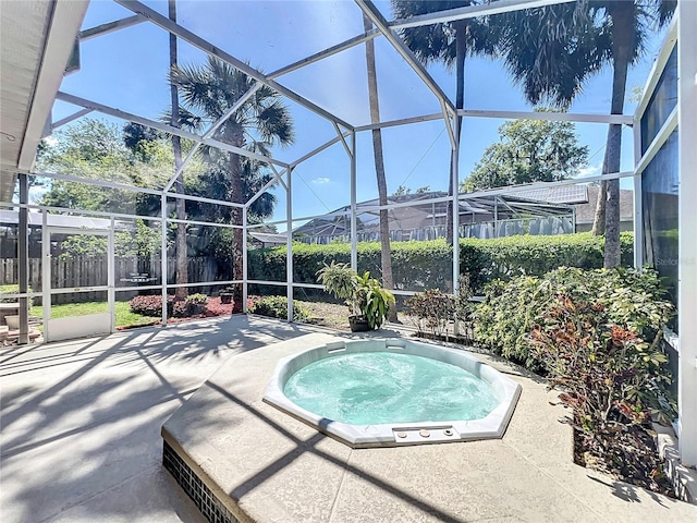 view of pool with glass enclosure, an in ground hot tub, fence, and a patio