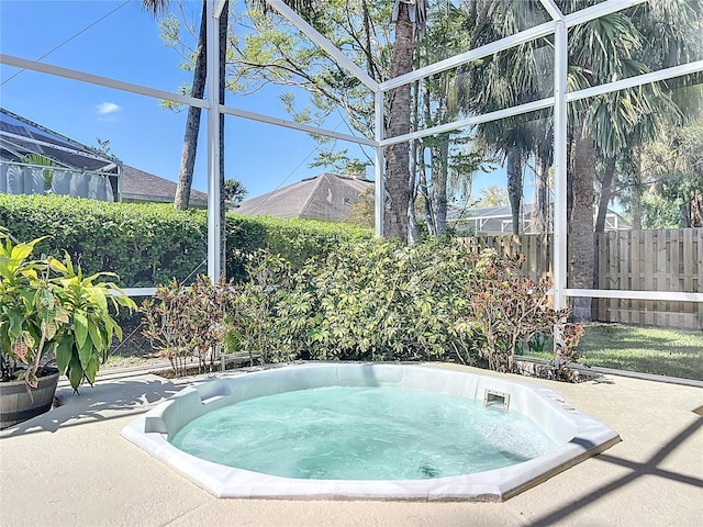 view of pool with a lanai, a patio, an outdoor hot tub, and fence