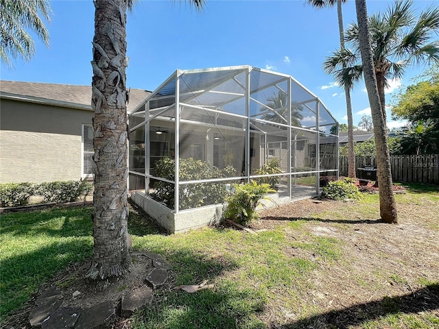 exterior space featuring a lanai and fence