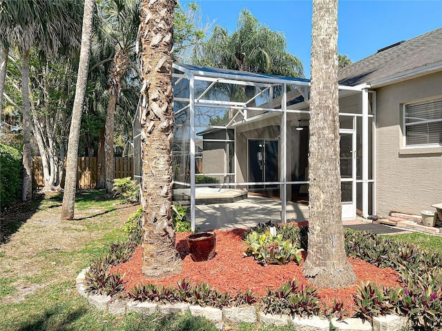 view of yard featuring a patio area, glass enclosure, and fence