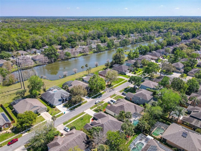 aerial view with a residential view, a view of trees, and a water view