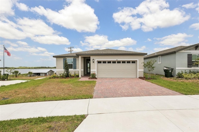 800 Griffon Ave, Lake Alfred, FL 33850 - view of front of property with decorative driveway, stucco siding, an attached garage, and a front lawn