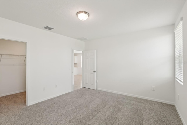 800 Griffon Ave, Lake Alfred, FL 33850 - unfurnished bedroom featuring carpet, a spacious closet, a closet, and baseboards