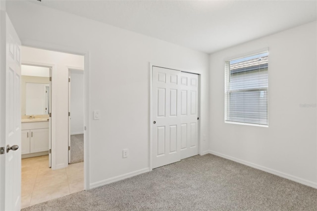 800 Griffon Ave, Lake Alfred, FL 33850 - unfurnished bedroom featuring light colored carpet, baseboards, a closet, and a sink