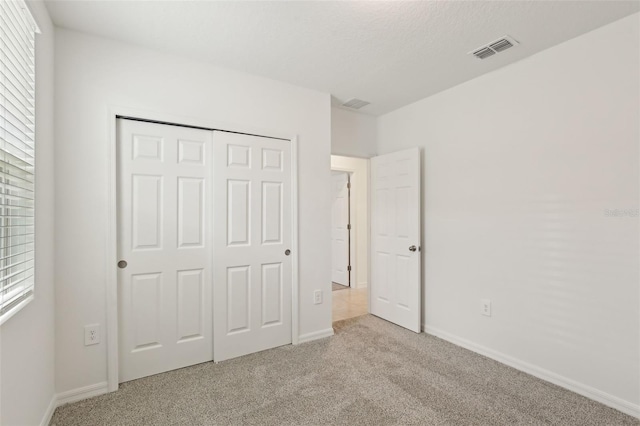 800 Griffon Ave, Lake Alfred, FL 33850 - unfurnished bedroom featuring carpet flooring, multiple windows, a closet, and baseboards