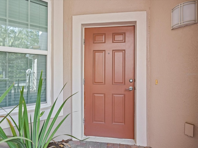 entrance to property featuring stucco siding