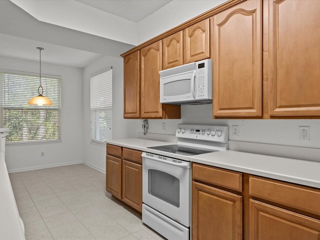 kitchen with pendant lighting, white appliances, brown cabinetry, light countertops, and baseboards