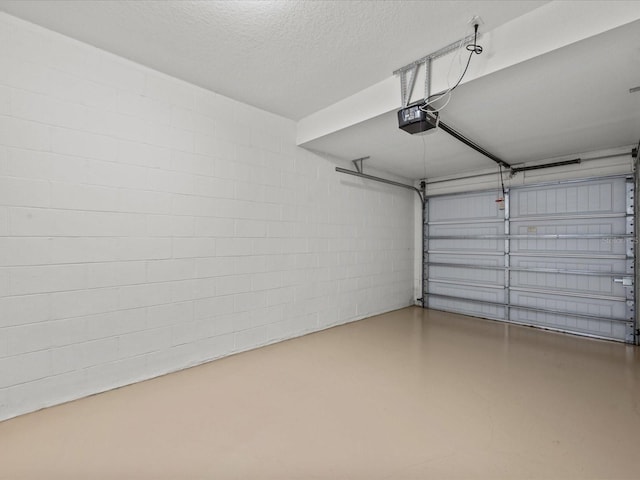 garage featuring a garage door opener and concrete block wall