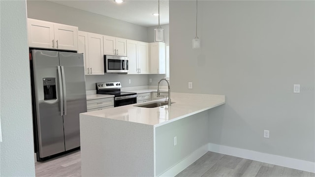 15369 SW 60th Cir, Ocala, FL 34473 - kitchen with appliances with stainless steel finishes, light wood-type flooring, a sink, a peninsula, and white cabinets