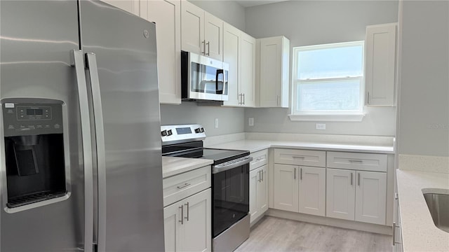 15369 SW 60th Cir, Ocala, FL 34473 - kitchen featuring appliances with stainless steel finishes, white cabinets, and light wood-style floors