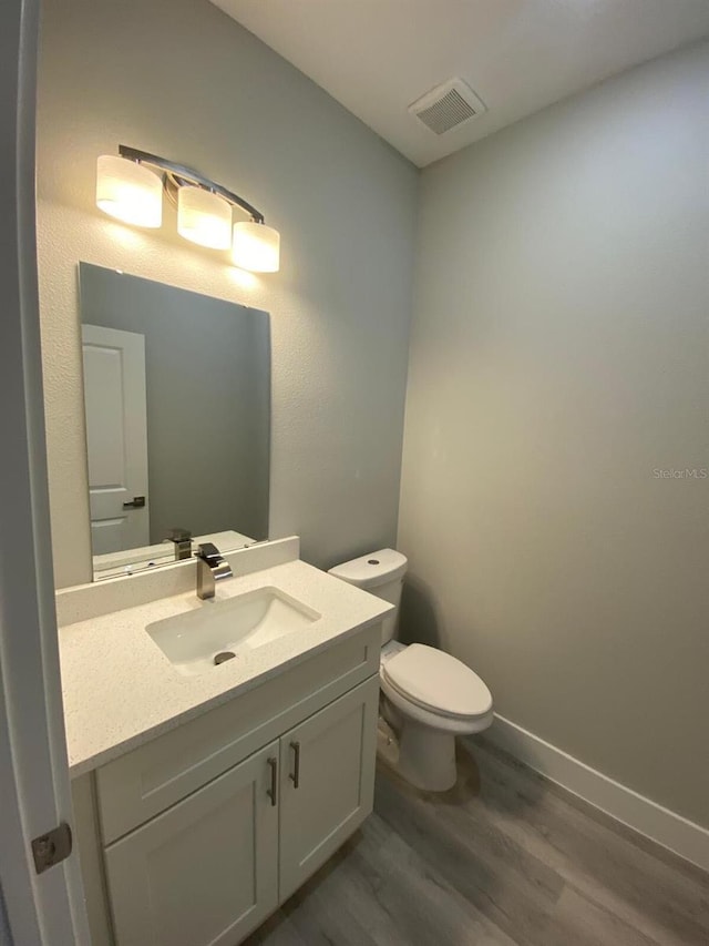 15369 SW 60th Cir, Ocala, FL 34473 - bathroom featuring wood finished floors, vanity, toilet, and baseboards