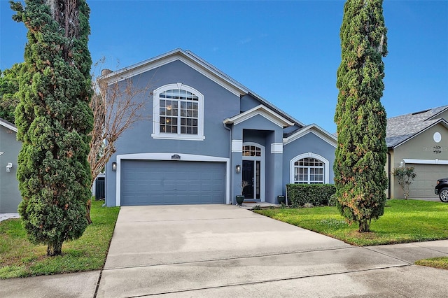 view of front of property with stucco siding, driveway, an attached garage, and a front yard