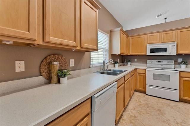 kitchen with white appliances, visible vents, light brown cabinetry, a sink, and light countertops