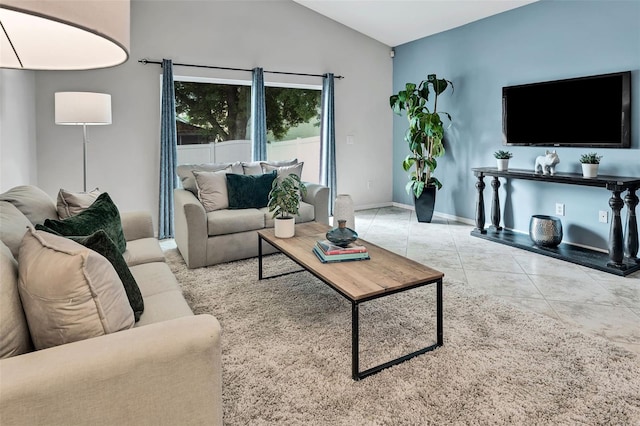 living area with tile patterned floors, baseboards, and lofted ceiling